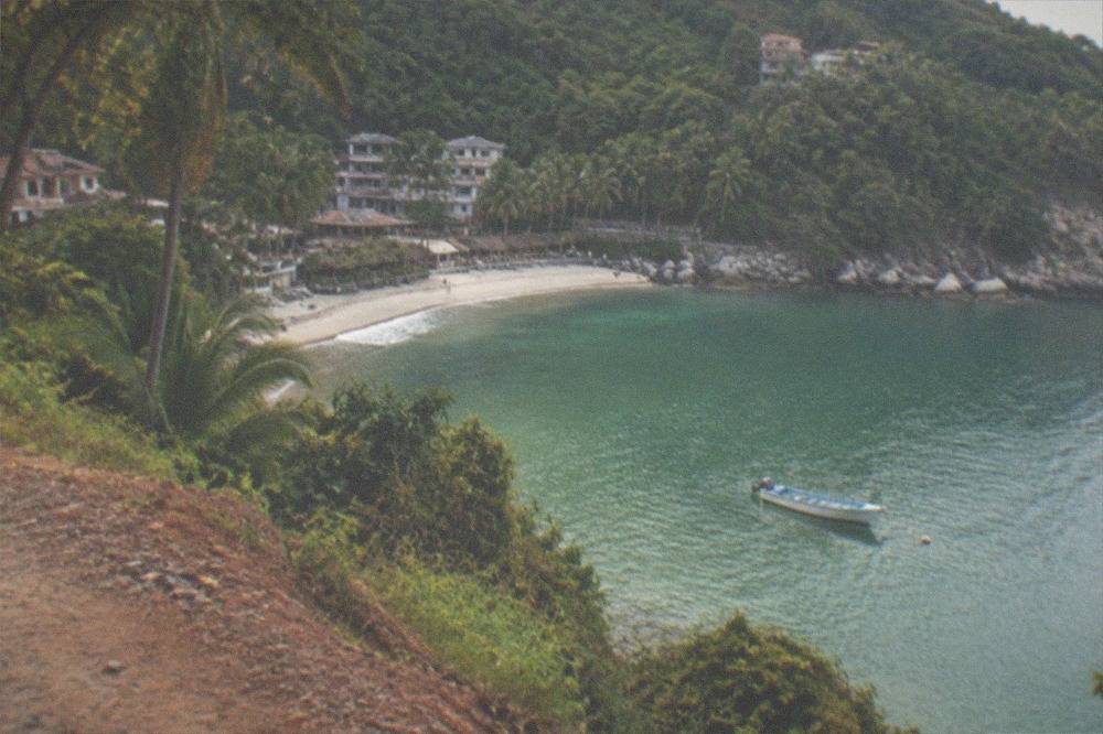 A coastal road south of Puerto Vallarta with a small boat anchored offshore