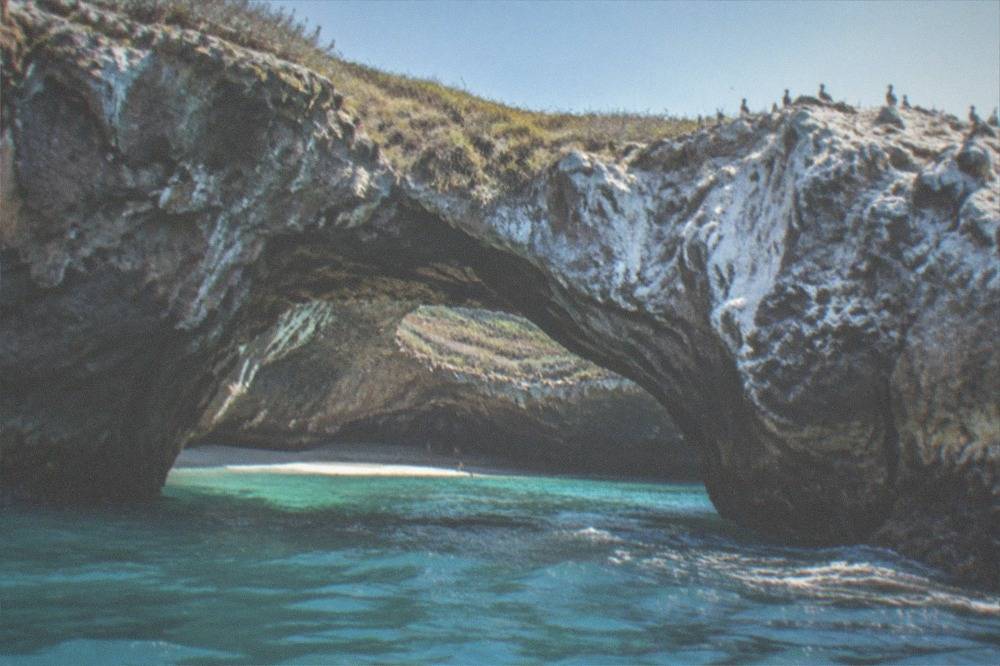 The rock arch of the hidden beach at the Marietas Islands above turquoise water