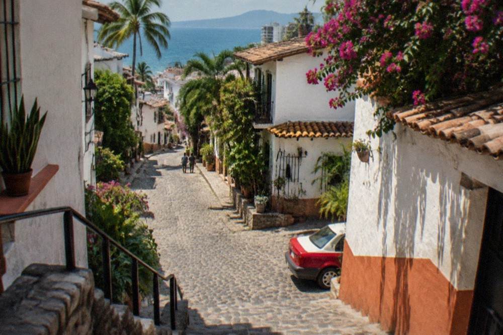 A narrow cobblestone street in old town Puerto Vallarta lined with colorful buildings