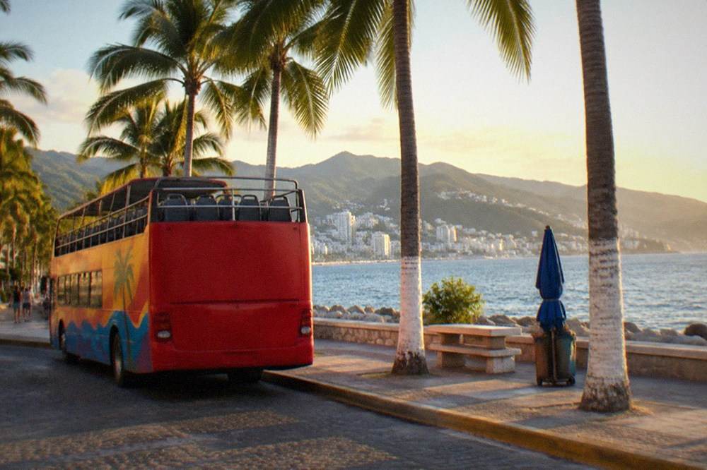 Open-top tour bus parked on a Puerto Vallarta street near the waterfront