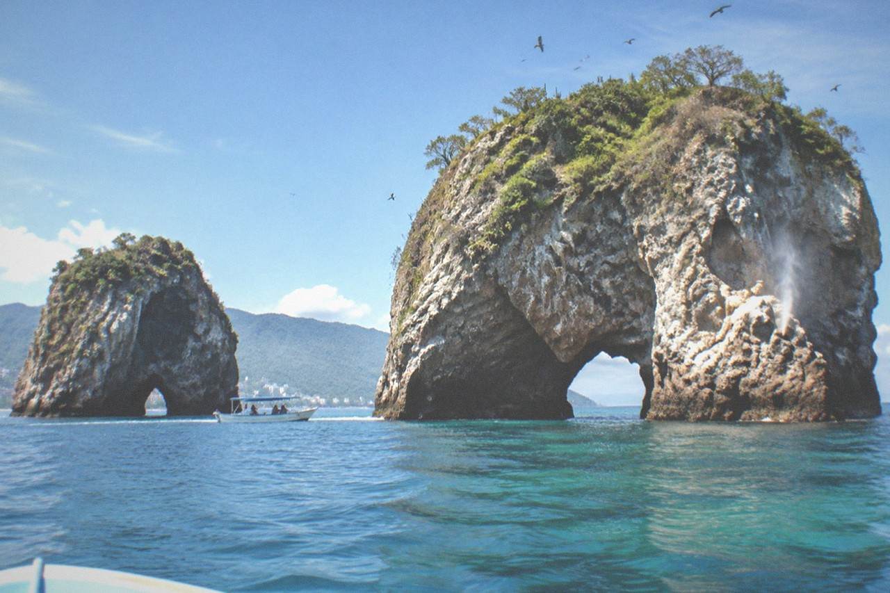 Snorkelers float in calm water among the rocky islands of Los Arcos in Banderas Bay, Mexico.